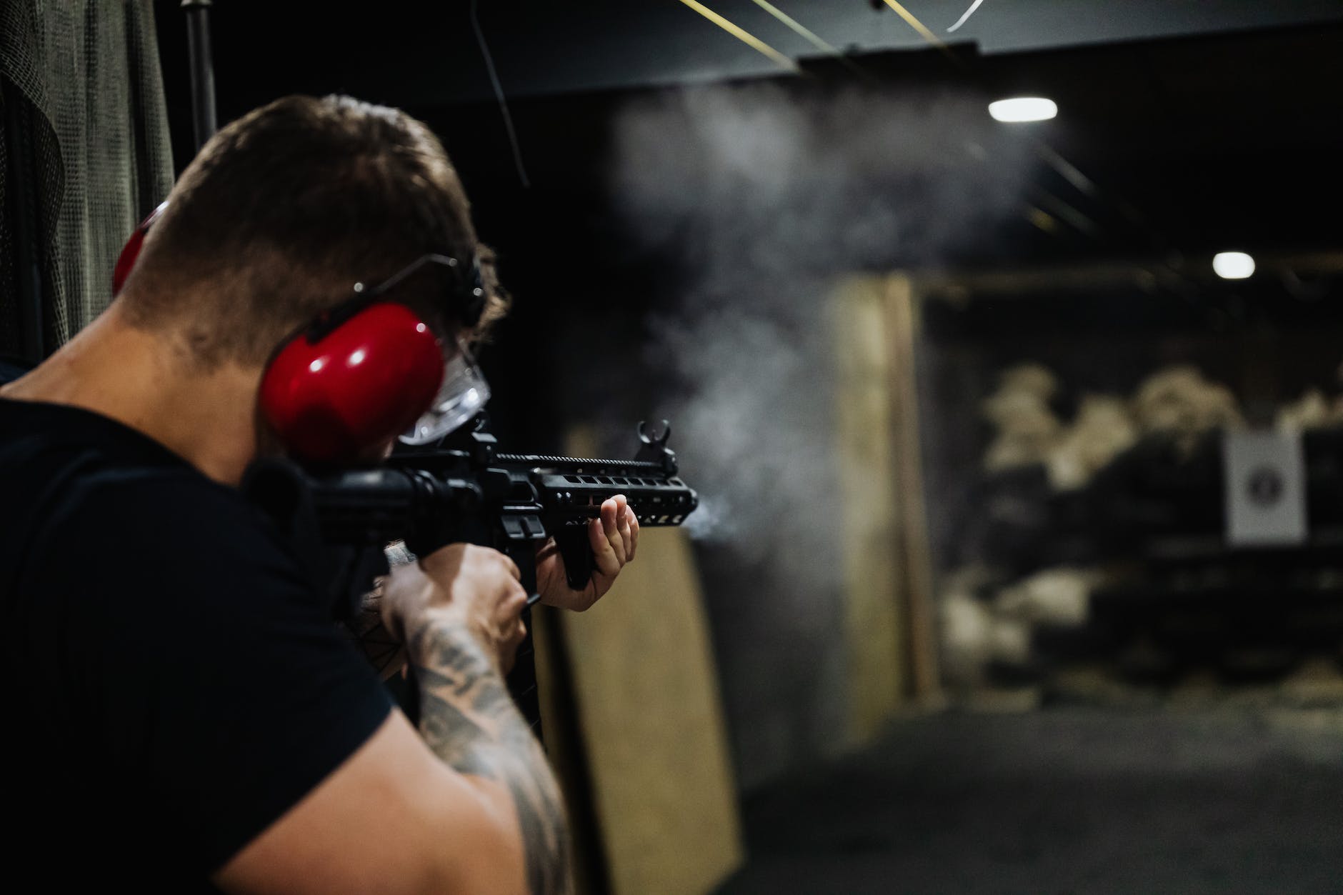 man in black t shirt holding black assault rifle